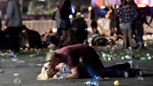 A man lays on top of a woman as others flee the festival grounds. The woman reportedly got up from the scene.