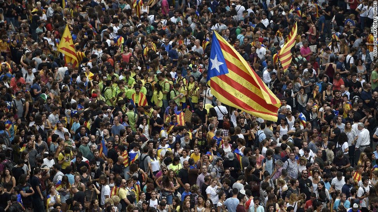 Protesters wave a Catalan pro-independence &#39;Estelada&#39; flag as they gather at the Placa de la Universitat square in Barcelona during a general strike in Catalonia called by Catalan unions on October 3, 2017.
