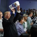 President Donald Trump tosses paper towels into a crowd as he hands out supplies at Calvary Chapel, Tuesday, Oct. 3, 2017, in Guaynabo, Puerto Rico. Trump is in Puerto Rico to survey hurricane damage. (AP Photo/Evan Vucci)