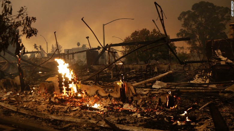 Flames rise from the remains of a burned commercial building Monday in Santa Rosa, California.