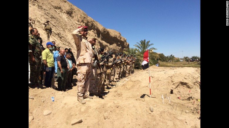 Iraqi soldiers salute a mass grave that is thought to hold as many as 1,700 bodies that were killed in the Camp Speicher massacre. 