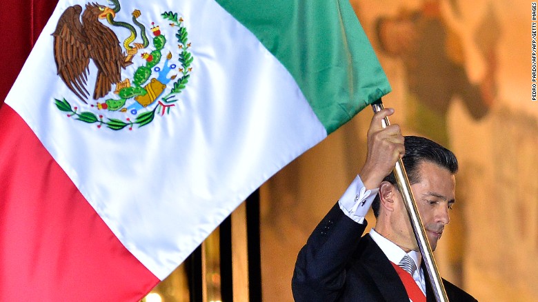 President Enrique Pena Nieto waves the Mexican National Flag.
