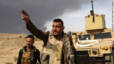 TOPSHOT - CORRECTION - A member of Iraqi forces gestures as troops head to the frontline on October 18, 2016 near the town of Qayyarah, south of Mosul, during the operation to recapture the city from the Islamic State group.
Tens of thousands of Iraqi forces were making gains on the Islamic State group in Mosul in an offensive US President Barack Obama warned would be a &quot;difficult fight&quot;. A massive cloud of dark grey smoke blots out the horizon as the result of oil wells being set afire by IS in an effort to provide cover from air strikes. / AFP PHOTO / BULENT KILIC / The erroneous mention[s] appearing in the metadata of this photo by BULENT KILIC has been modified in AFP systems in the following manner: [date is October 18] instead of [October 16]. Please immediately remove the erroneous mention[s] from all your online services and delete it (them) from your servers. If you have been authorized by AFP to distribute it (them) to third parties, please ensure that the same actions are carried out by them. Failure to promptly comply with these instructions will entail liability on your part for any continued or post notification usage. Therefore we thank you very much for all your attention and prompt action. We are sorry for the inconvenience this notification may cause and remain at your disposal for any further information you may require.BULENT KILIC/AFP/Getty Images