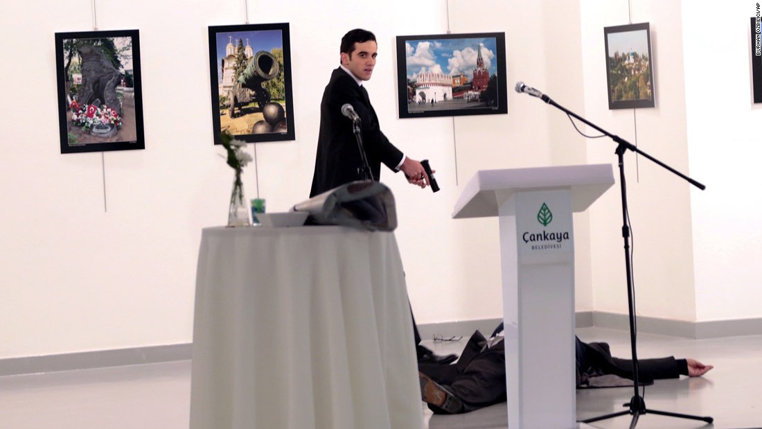 ADDS THE NAME OF THE GUNMAN - A man identified as Mevlut Mert Altintas stands over Andrei Karlov, the Russian Ambassador to Turkey, after shooting him at a photo gallery in Ankara, Turkey, Monday, Dec. 19, 2016. Karlov, 62, was several minutes into a speech at the embassy-sponsored exhibition when Altintas fatally shot him in front of stunned onlookers. (AP Photo/Burhan Ozbilici)