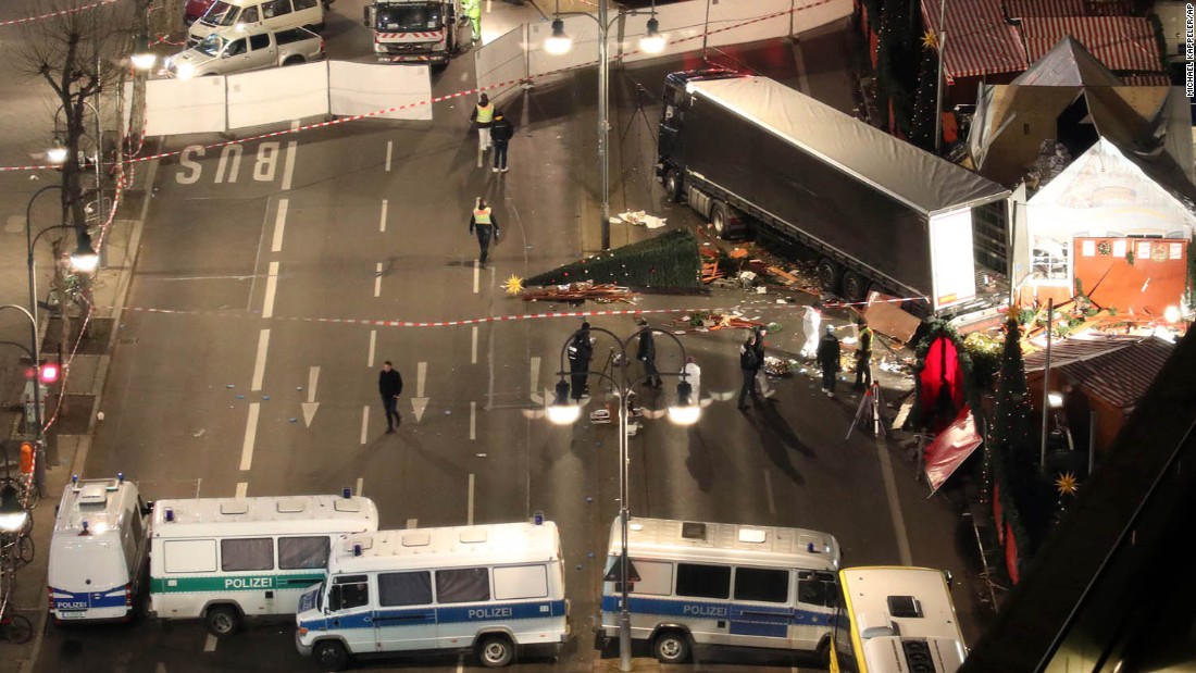 Police search the surroundings of a truck which run into a crowded Christmas market the evening before and killed several people in Berlin, Germany, early Tuesday, Dec. 20, 2017. (Michael Kappeler/dpa via AP)