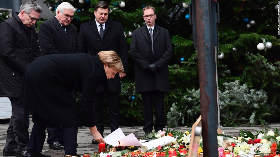 TOPSHOT - German Chancellor Angela Merkel (foreground), German Interior Minister Thomas de Maiziere (L) and German Foreign Minister Frank-Walter Steinmeier (2nd L) stand at a makeshift memorial for the victims of an attack on December 20, 2016 in front of the Kaiser-Wilhelm-Gedaechtniskirche (Kaiser Wilhelm Memorial Church) in Berlin, where a truck crashed into a Christmas market.
Twelve people were killed and almost 50 wounded, 18 seriously, when the lorry tore through the crowd on December 19, 2016, smashing wooden stalls and crushing victims, in scenes reminiscent of July&#39;s deadly attack in the French Riviera city of Nice. / AFP PHOTO / Tobias SCHWARZTOBIAS SCHWARZ/AFP/Getty Images