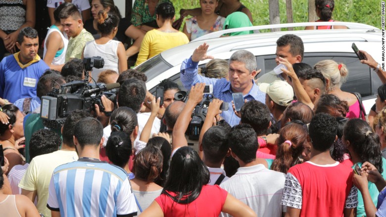 An unidentified man speaks to relatives of inmates and to the media near the main gate prison complex.