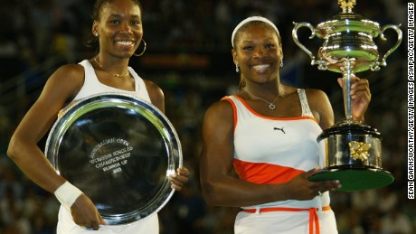 Serena Williams R) holds the winners trophy and her sister Venus Williams holds the runners up trophy after the women&#39;s singles final during the Australian Open at Melbourne Park on January 25, 2003. 