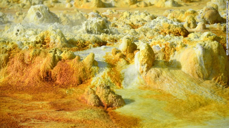 Temperatures average 34.5 degrees Celsius but have risen to over 50 degrees. Rocks are colored by minerals and algae.