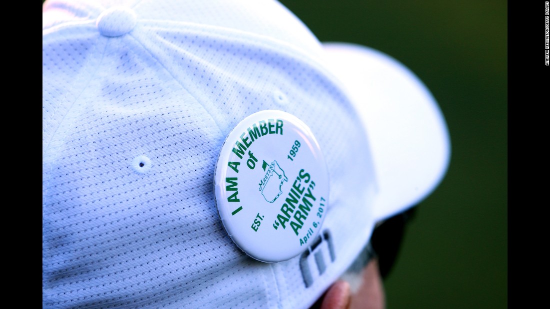 A fan wears a pin in honor of Arnold Palmer.