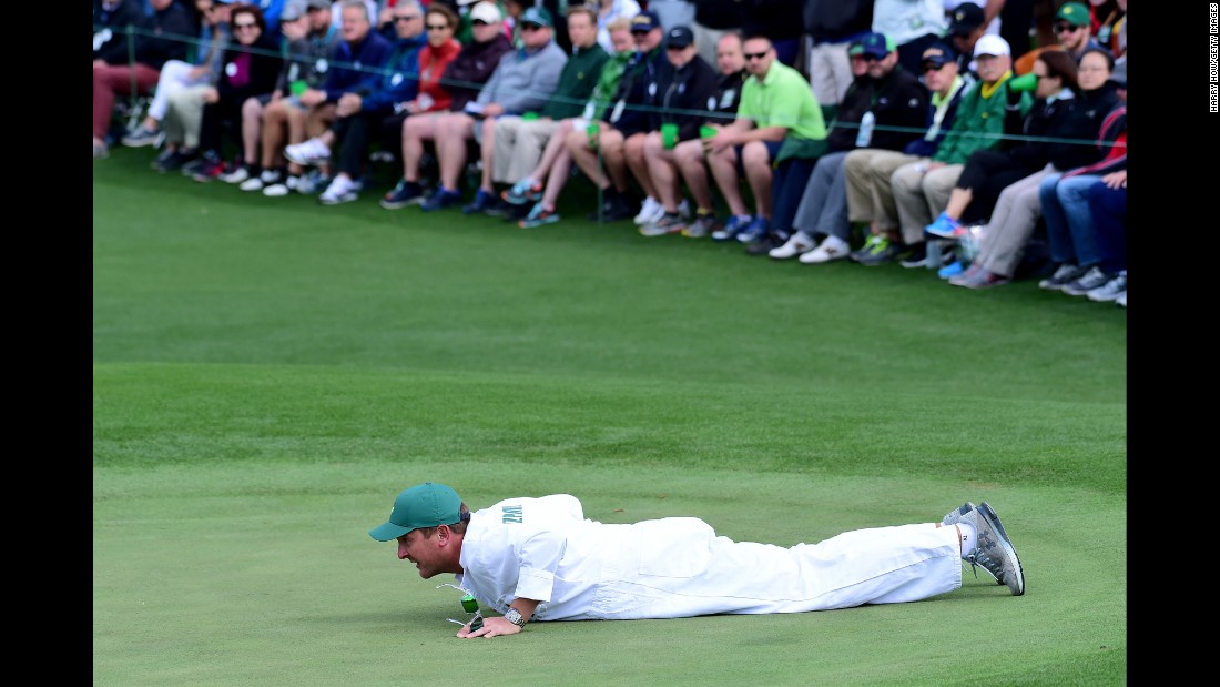 Jamie Lane, caddie for Matthew Fitzpatrick, lines up a putt.