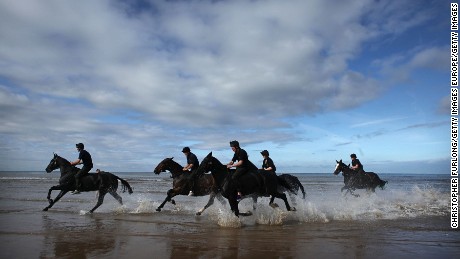 BLACKPOOL, ENGLAND - SEPTEMBER 16:  Gunners and horses of The Kings Troop Royal Artillery cool  off in the surf after a gallop along the beach during their annual holiday break in the seaside resort of Blackpool on September 16, 2009 in Blackpool, England. The horses and gunners of Left Section, The King?s Troop Royal Horse Artillery, are taking a break for their usual ceremonial duties in central London to enjoy a short holiday in Blackpool.  They are guests of the World Horse Welfare&#39;s stables at Penny Farm.  (Photo by Christopher Furlong/Getty Images)