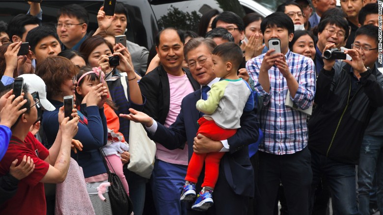 South Korean presidential candidate Moon Jae-In poses with a boy in Seoul on May 9.