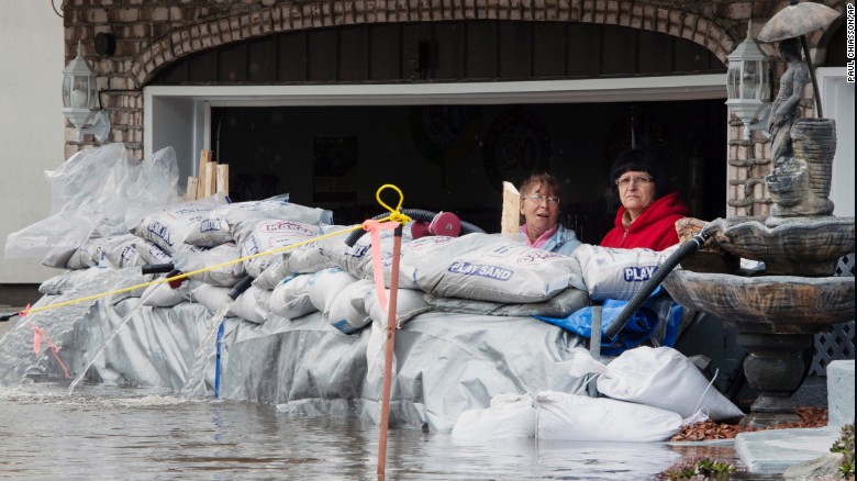 Residents look out from their garage over sandbags in Ile Bizard, Quebec.