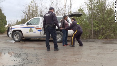 Canadian police detain a Haitian immigrant who just crossed the border.