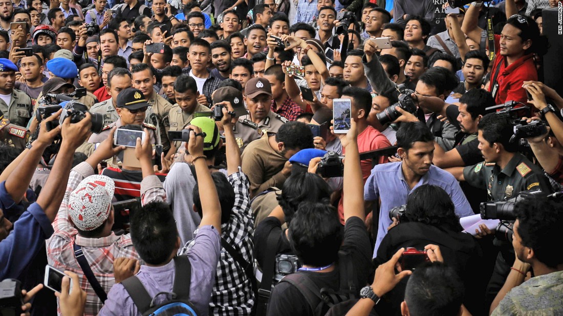 Men convicted of gay sex, center, are mobbed and filmed as they head to a mosque to be punished in May.