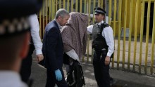 Police officers escort a person, with their head covered, to a police van, in Barking, east London on June 5, 2017, following a dawn raid on a property (R), as thier investigations continue following the June 3 terror attacks in central London.
Police carried out fresh raids and arrested &quot;a number of people&quot; on Monday after the Islamic State group claimed an attack by three men who mowed down and stabbed revellers in London on June 3, killing seven people, before being shot dead by officers. / AFP PHOTO / Daniel LEAL-OLIVAS        (Photo credit should read DANIEL LEAL-OLIVAS/AFP/Getty Images)