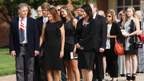 Fred and Cindy Warmbier, left and center, watch as the casket of their son is carried out of his funeral.