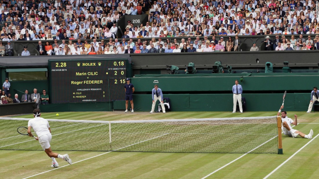 Cilic tumbles as Federer chases down a return. 