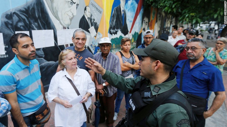 Voters receive instructions by a Venezuelan Bolivarian National Guard officer outside a polling station during the election for a constitutional assembly in Caracas, Venezuela, Sunday, July 30, 2017. 