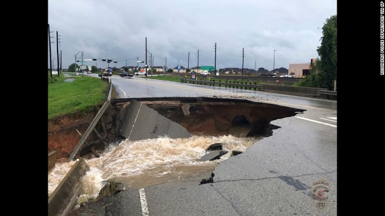 Water rushes from a large sinkhole along a highway in Rosenberg, Texas, on August 27.