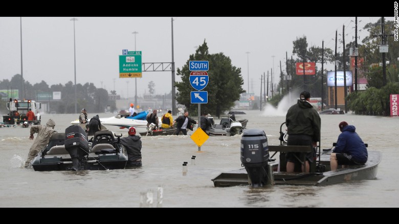 Volunteer rescue boats make their way into a flooded subdivision in Spring, Texas, on August 28.