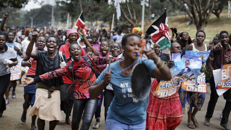Supporters of opposition leader Raila Odinga celebrate in Uhuru Park, some carrying Kenyan flags and posters of Odinga.