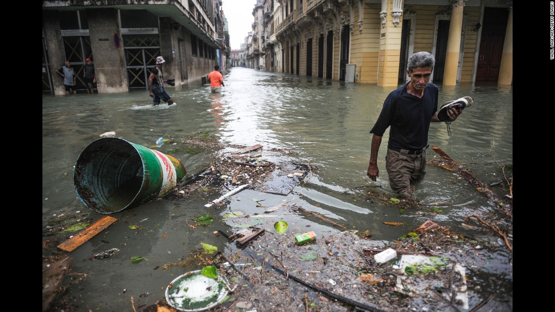 Cubans wade through debris and water in flooded streets in Havana on Sunday, September 10.