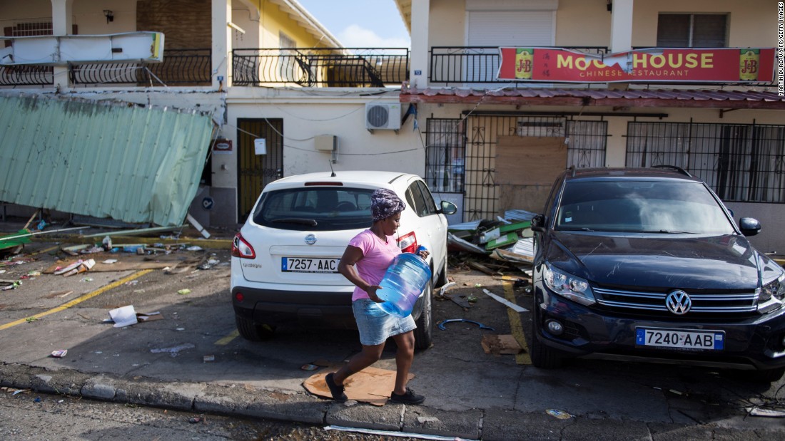 A woman carries a container of water on September 10 on a street in Marigot on the island of St. Martin after it was devastated by Hurricane Irma.