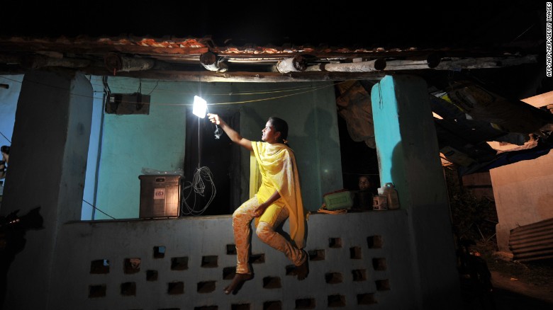A girl switches on a light powered by solar energy in the village of Morabandar on Elephanta Island, off the coast of Mumbai.