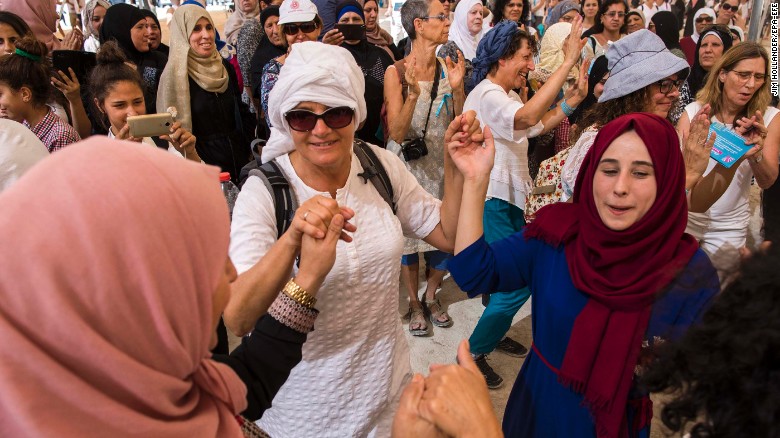 Israeli and Palestinian women dance together under a large tent during the mass protest.